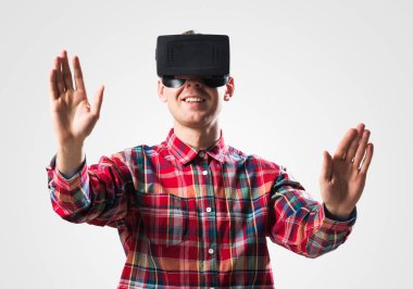 Ekose desenli gömlek gri arka plan karşı sanal kask giymiş genç adam