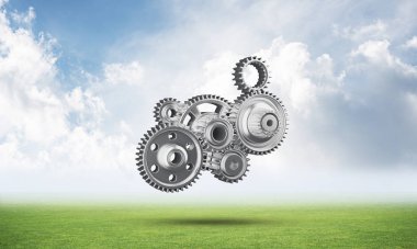 Yeşil çayır üzerinde dişli tekerlekler ile soyut mekanizma