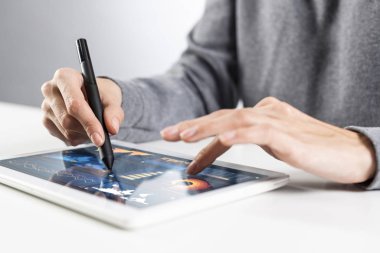 Kadın ellerinin dijital tablet ekranına dokunuşunun yakın çekimi. İş kadını masada oturuyor ve tablet bilgisayarında çalışıyor. Ofisteki işyerinde danışman. İş ve dijital teknoloji kavramı.
