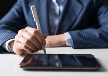 Dijital tablet bilgisayar kullanarak iş elbisesi giyen adam. Erkek el tutan kalem ve tablet cihazının yakın çekim. Ofisteişyerinde iş adamı. İş dünyasında mobil akıllı cihaz.