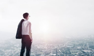 Omzunda ceketi olan genç ve zarif bir iş adamı başka tarafa bakıyor.