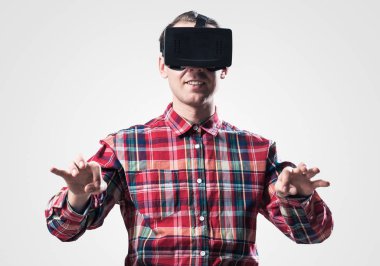 Ekose desenli gömlek gri arka plan karşı sanal kask giymiş genç adam