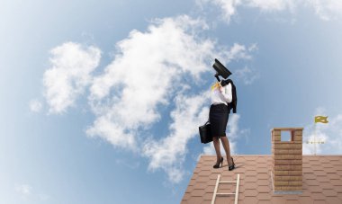 Evin çatısında baş durmak yerine kamerayla zum yapan yüzsüz iş kadını.