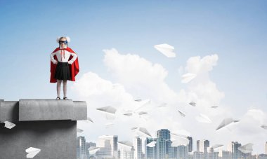 Süper kahraman kostümü çatı yapı üzerinde duran genç kız. Karışık teknik