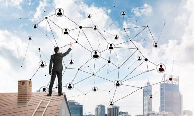 Delikanlı çatıda dikiliyor ve bağlantı hatları çiziyor. Karışık ortam