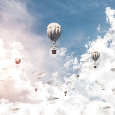 Renkli aerostats kağıt uçaklar arasında ve mavi bulutlu gökyüzü üzerinde uçan. 3D render.