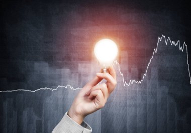Grunge arka planında parlak parlak lamba ve iş bilgisi olan insan eli. Organizasyon ve motivasyon kavramı. Çevrimiçi iş istatistikleri ve analizleri.