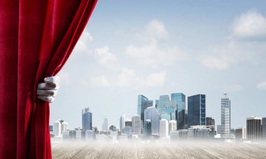 İnsan eli modern cityscape ve bulutlu gökyüzü kırmızı kadife perde açılır
