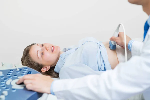 超音波検査で幸せな女性 超音波機器による出生前診断 定期的な検査と病気の予防 笑顔妊娠中の女性が病院を訪れ 腹のソノグラフィーを行います — ストック写真