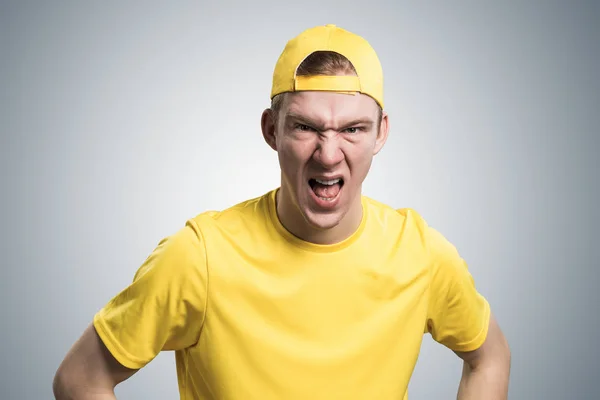 法国少年怒气冲冲地大叫 情绪激动的红头发男孩满脸怒容 男人的画像 穿着黄色T恤 头戴灰色背景的棒球帽 情感和表达概念 — 图库照片