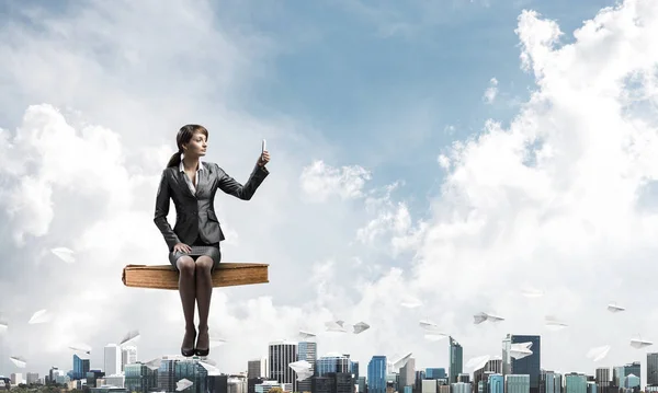 Chica en traje de negocios volando en el cielo azul libro grande —  Fotos de Stock