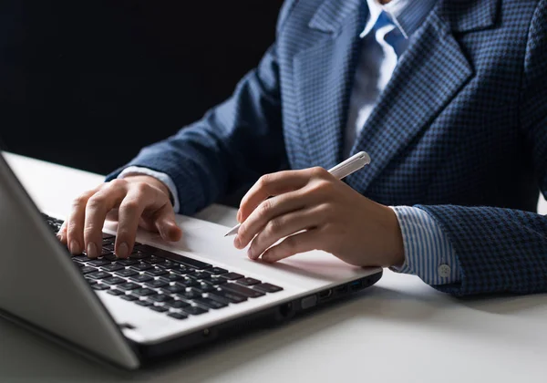 ビジネススーツを着た男性が机に座り ラップトップコンピュータで働いている ペンを持ち キーボードを入力する人間の手のクローズアップ 職場のビジネスマン ビジネスとデジタル技術 — ストック写真