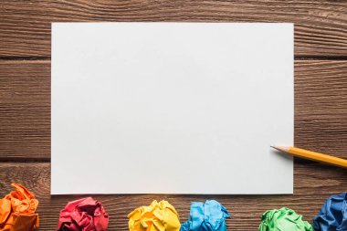 Tahta masadaki beyaz kağıt ve kalemi kapat.