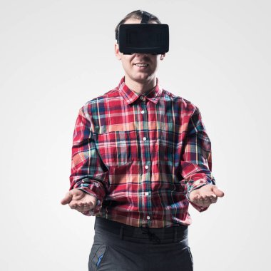 Ekose desenli gömlek gri arka plan karşı sanal kask giymiş genç adam
