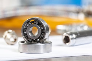 Boru hattı ve bilyeler masanın üzerinde duruyor. Su tesisatları ve örgülü hortum parçaları. Motor mekanizmaları için çelik detaylar. Ev altyapısı tasarım ve kurulum