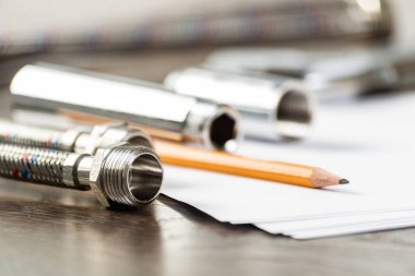 Yeni esnek hidrolik sistem elemanları. Örgülü hortum segmentleri ile su bağlantı larını ve bağlantılarını kapatın. Sıhhi tesisat boru hattı masada. Profesyonel tasarım ve montaj sıhhi tesisat boru hatları