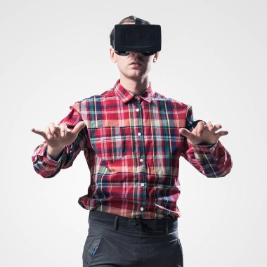 Ekose desenli gömlek gri arka plan karşı sanal kask giymiş genç adam
