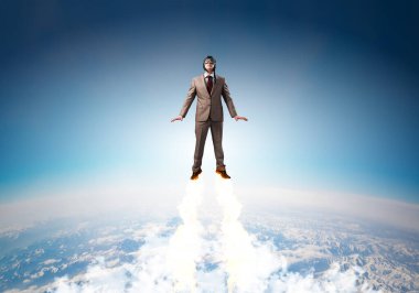 Mavi gökyüzünde süper kahraman olarak uçan takım elbiseli ve havacı şapkalı bir iş adamı. Şirket yöneticisi süper kahraman olarak stratosferde jet aleviyle yukarı doğru fırlatılıyor. Başarılı iş kurma motivasyon kavramı