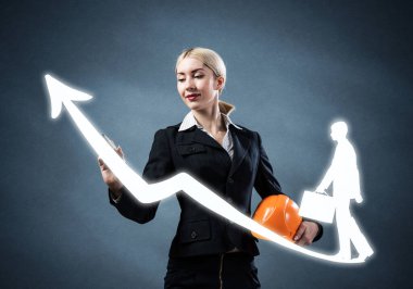 İş kadını profesyonel kariyer grafiği çiziyor. Strateji planlama ve geliştirme sunumu. İş yerinde büyüme ve kişisel gelişim. Güvenlik kaskıyla iş elbisesi içinde insan kaynakları danışmanı..
