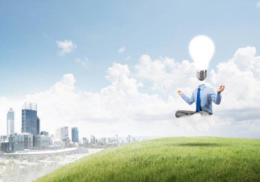 Nilüfer çiçeği pozu ve ampulde oturan bir iş adamı.