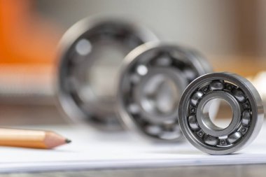 Kağıt yaprağın üzerinde üç farklı bilye var. Ağır endüstri mühendislik şirketi. Otomotiv tasarımı ve üretimi. Makineler için yedek parça. Motor mekanizmaları için çelik ayrıntıları.