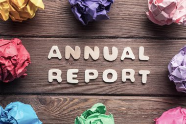 Ahşap masa üzerinde daire içine yerleştirilmiş renkli kağıt toplar.