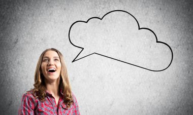 Mutlu sevimli kız geniş gülümseyen. Duygusal genç kadın yüz ifadesini şaşırttı. Gri duvarda boş konuşma balonu illüstrasyon. Güzel kız portresi kırmızı damalı gömlek giyer.