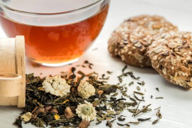 Bitkisel çay otları ve kurabiyeler masada.