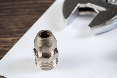 Boru hattı elementi ve ayarlanabilir anahtar masanın üzerinde. Çelik su tesisatları ve hidrolik sistem bağlantıları. Banyo tamiri veya inşaat hizmetleri için yeni ekipman.