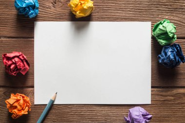 Tahta masadaki beyaz kağıt ve kalemi kapat.