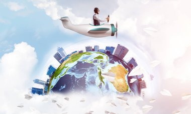 Havacı şapkalı, gözlüklü, pervaneli bir adam. Yüksek modern binalarla dolu bir dünya küresi. Küçük uçakta eğlenen komik adam. Mavi bulutlu gökyüzü, uçan sıcak hava balonları ve kağıt uçaklar