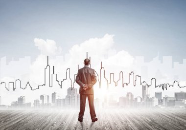 İşadamı arkasını dönüp modern iş merkezinin siluetine bakıyor.