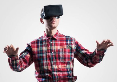 Ekose desenli gömlek gri arka plan karşı sanal kask giymiş genç adam