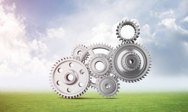 Yeşil çayır üzerinde cogwheels ile soyut mekanizma. İnşaat ve üretim. Mekanik teknoloji makine mühendisliği. Yeşil çimen ve mavi gökyüzü ile doğa manzara. 3b nesneile karışık ortam