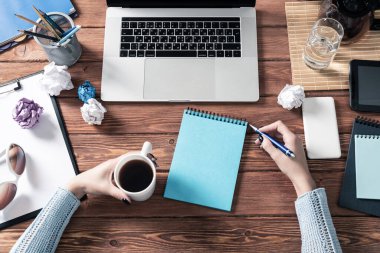 Bilgisayarda çalışan serbest çalışan bir kadın. İş yerinde kahve molası. Çevrimiçi iş eğitimi konsepti. Kadın eli ve klavyesi olan düz bir ofis işyeri. Lawler belgelerle çalışıyor