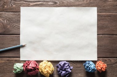 Tahta masadaki beyaz kağıt ve kalemi kapat.