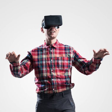 Ekose desenli gömlek gri arka plan karşı sanal kask giymiş genç adam