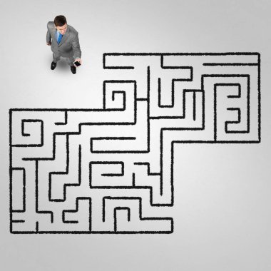 Kafası karışmış işadamının yukarıdaki manzarası yerde çizilmiş labirente bakıyor.