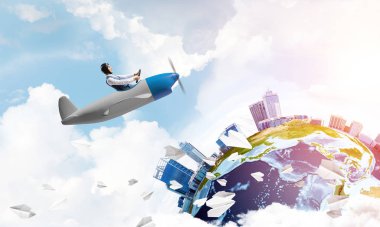 Küçük uçağın kamarasında oturan neşeli genç pilot. Havacı şapkalı, gözlüklü, pervaneli, komik bir adam. Uçakla dünyayı dolaşmak. Dünya küresi bulutlu gökyüzü manzaraları arasında.