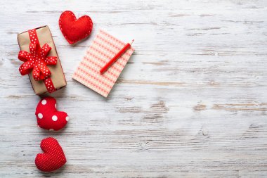 Dümdüz, el yapımı, kırmızı kalplerle hoş bir kompozisyon sergiliyordu. Hediye kutusu ve defter ahşap masada. Doğum günün kutlu olsun ya da yıldönümün kutlu olsun. Kopyalama alanı ile romantik aşk hikayesi.