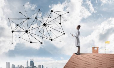 Confident medical industry employee standing on brick roof and examining network structure. Modern technologies for medical industry