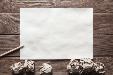 Tahta masadaki beyaz kağıt ve kalemi kapat.