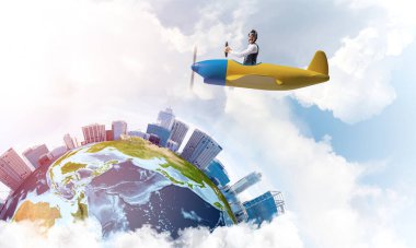 Küçük uçağın kamarasında oturan neşeli genç pilot. Havacı şapkalı, gözlüklü, pervaneli, komik bir adam. Uçakla dünyayı dolaşmak. Dünya küresi bulutlu gökyüzü manzaraları arasında.