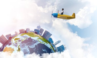 Küçük uçağın kamarasında oturan neşeli genç pilot. Havacı şapkalı, gözlüklü, pervaneli, komik bir adam. Uçakla dünyayı dolaşmak. Dünya küresi bulutlu gökyüzü manzaraları arasında.