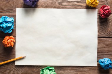 Tahta masadaki beyaz kağıt ve kalemi kapat.