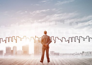 İşadamı arkasını dönüp modern iş merkezinin siluetine bakıyor.