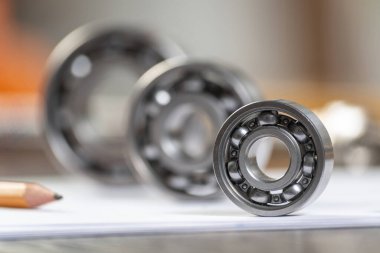 Kağıt yaprağın üzerinde üç farklı bilye var. Ağır endüstri mühendislik şirketi. Otomotiv tasarımı ve üretimi. Makineler için yedek parça. Motor mekanizmaları için çelik ayrıntıları.