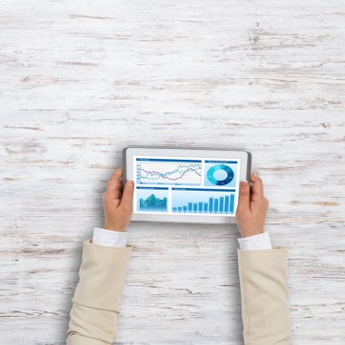 Diyagramlar ve grafikler ekran ile tablet pc kullanarak işkadını el Üstten Görünüm
