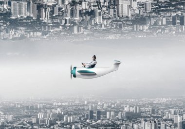 Deri kasklı uçak pilotu küçük bir uçağın kabininde oturuyor. Birbirine ters tespile nisken inananiki şehir dünyasının soyut görüntüsü. Yüksek binalar ve cam kuleleri ile modern metropol.