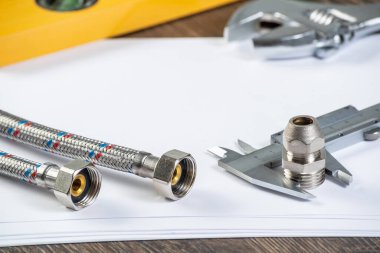 Çelik boru hattı konnektörü ve kalibreler beyaz kağıdın üzerinde. Tesisat hortum mühendisliği. Banyo tamiri ya da inşaat için yeni ekipman. Profesyonel tesisat teknik servisi..